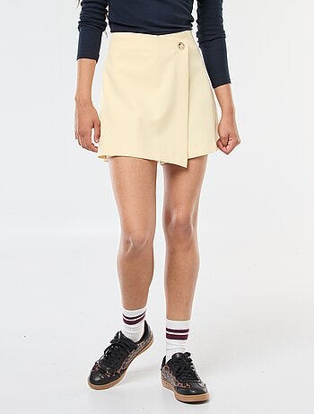 Jupe short asymétrique avec bouton doré