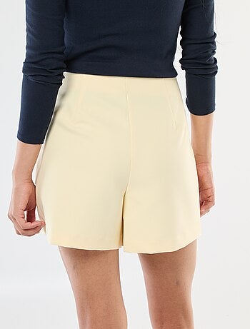 Jupe short asymétrique avec bouton doré