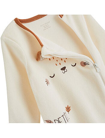 Babypyjama van karamelkleurig velours met ritssluiting.