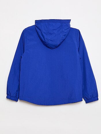 Coupe-vent uni qui se range dans sa capuche