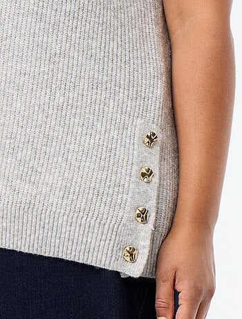 Mouwloze trui met goudkleurige sieraden