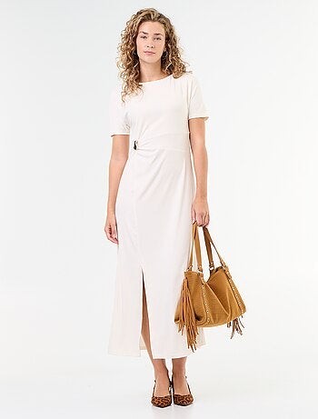Robe longue coupe plissée et broche dorée martelée.